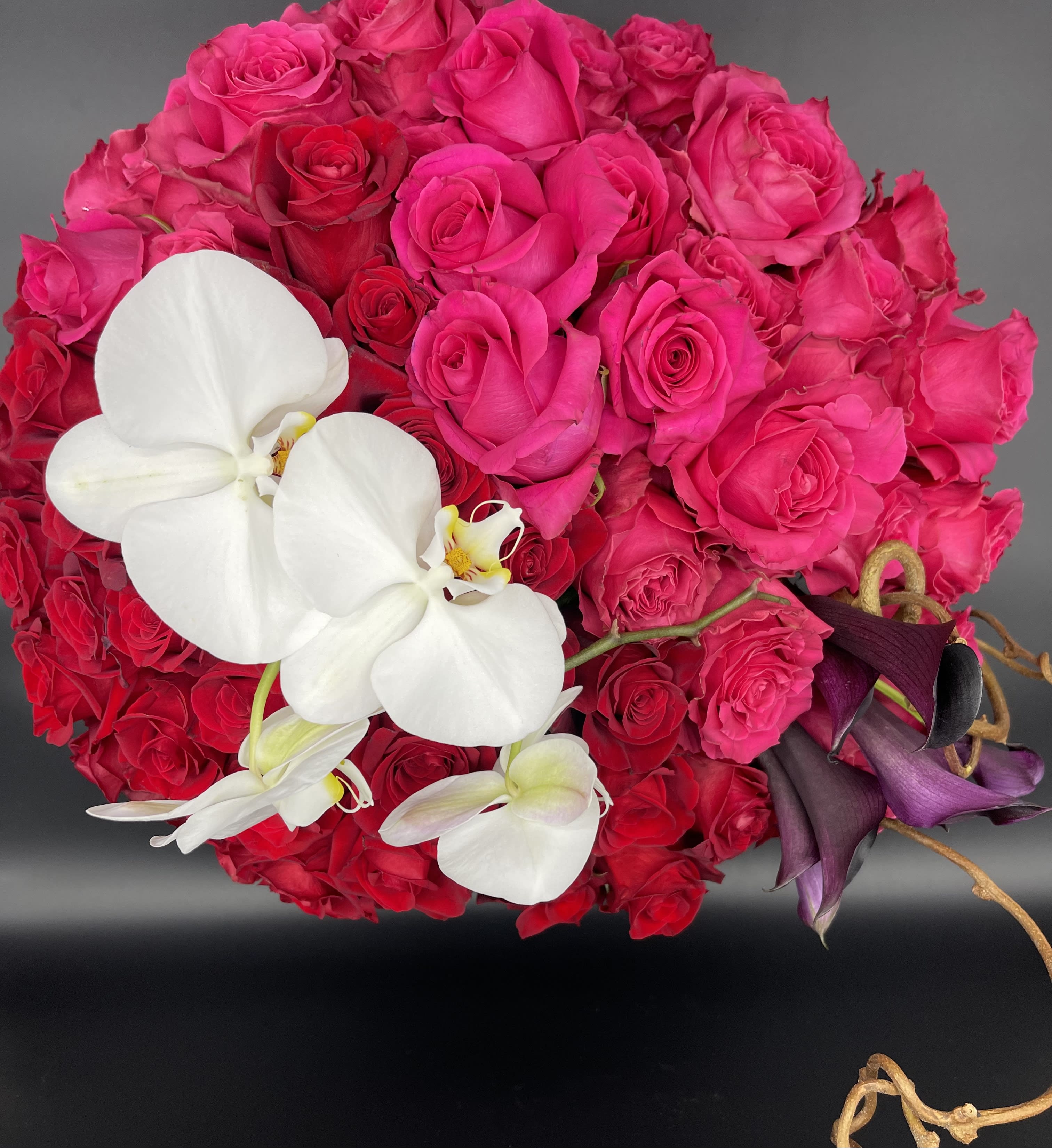 Bouquet of hot pink roses with white orchids and dark purple calla lilies