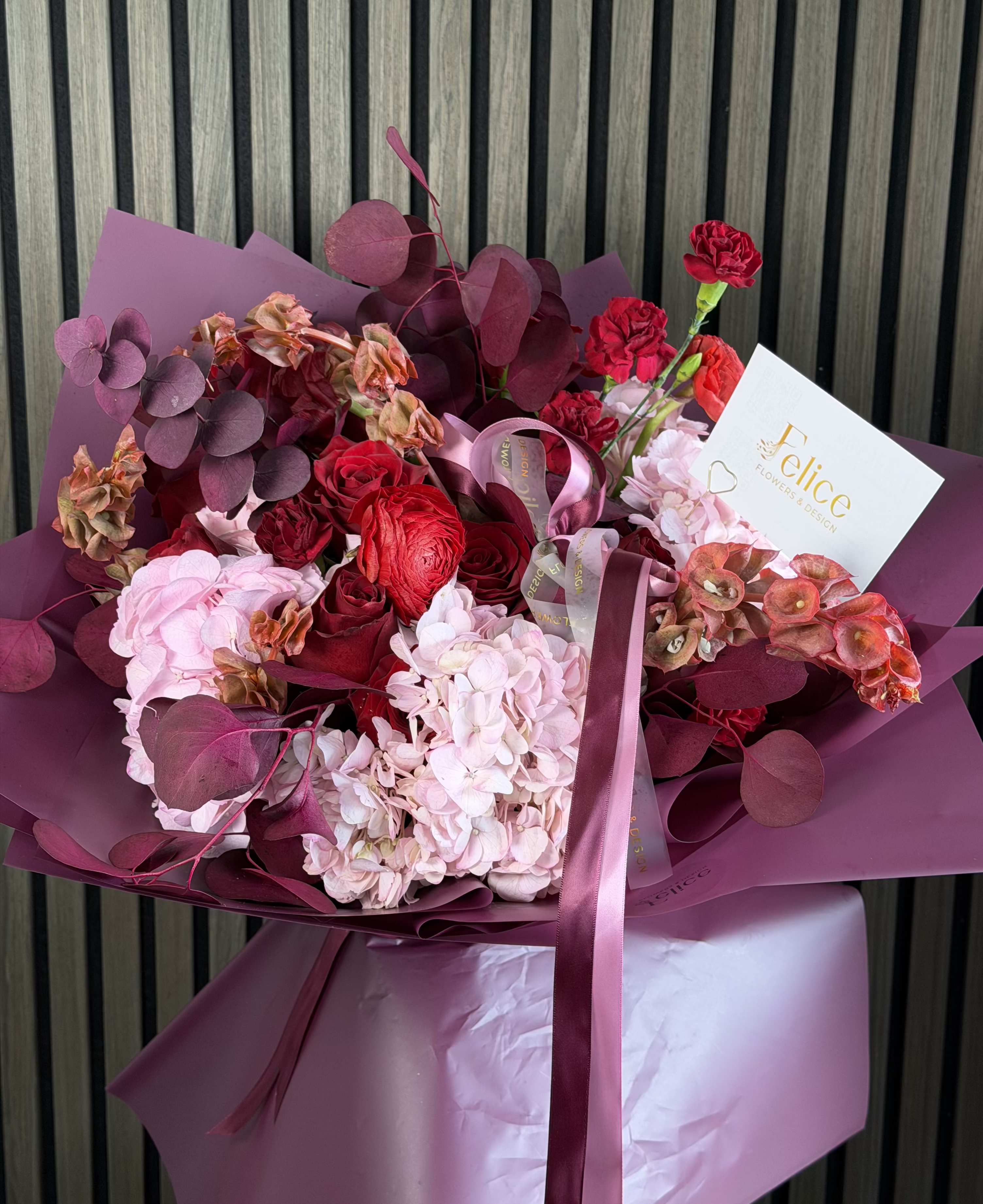Pink &amp; Red Luxury Romance Bouquet - An elegant and romantic flower bouquet blending soft blush pink hydrangeas with rich crimson roses and deep burgundy accents. This luxurious arrangement creates a perfect balance of softness and bold passion, making it a stunning statement piece for any special occasion. Designed with premium seasonal blooms and modern wrapping, this bouquet embodies sophistication, romance, and refined beauty. Perfect for Valentine’s Day, Anniversary, Love and Romance, Birthday, Thank You, and Just Because. Please note: due to seasonal availability, some flowers may be substituted. However, the color palette, bouquet size, overall style, and luxurious look will remain consistent with the photo. Handcrafted by Felice Flowers &amp; Design with attention to every detail.