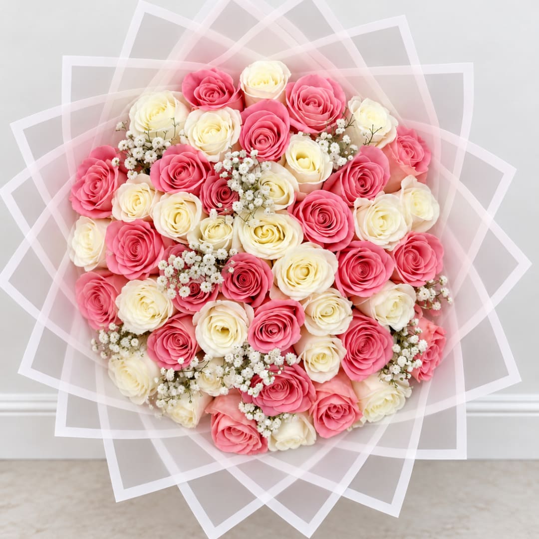 Round bouquet of pink and cream roses with baby's breath