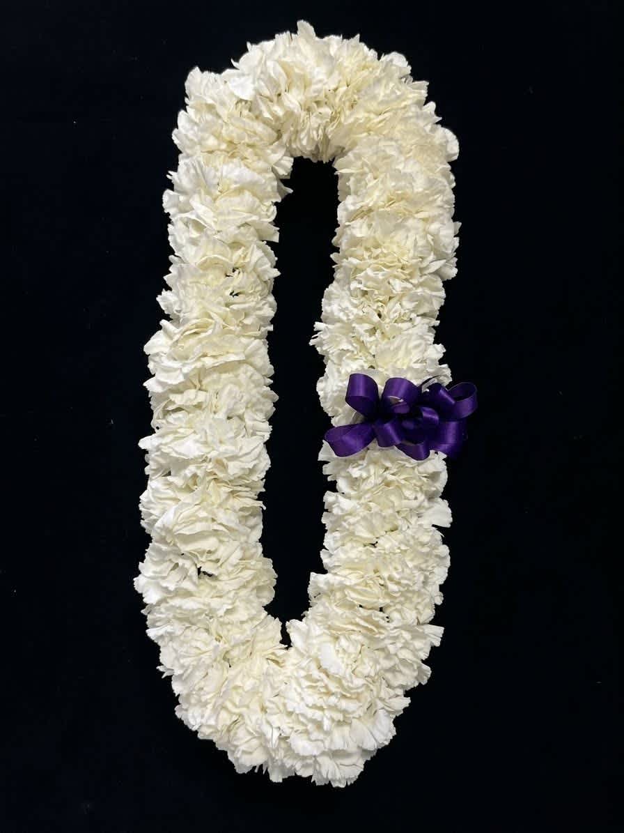 White floral lei with a purple ribbon on a black background