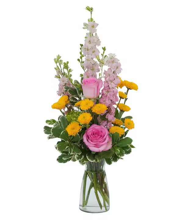 Pink roses and yellow pompon flowers in a clear glass vase