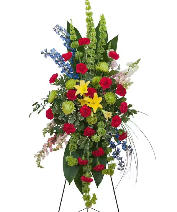Tall standing floral spray with red, yellow, blue, and green blooms