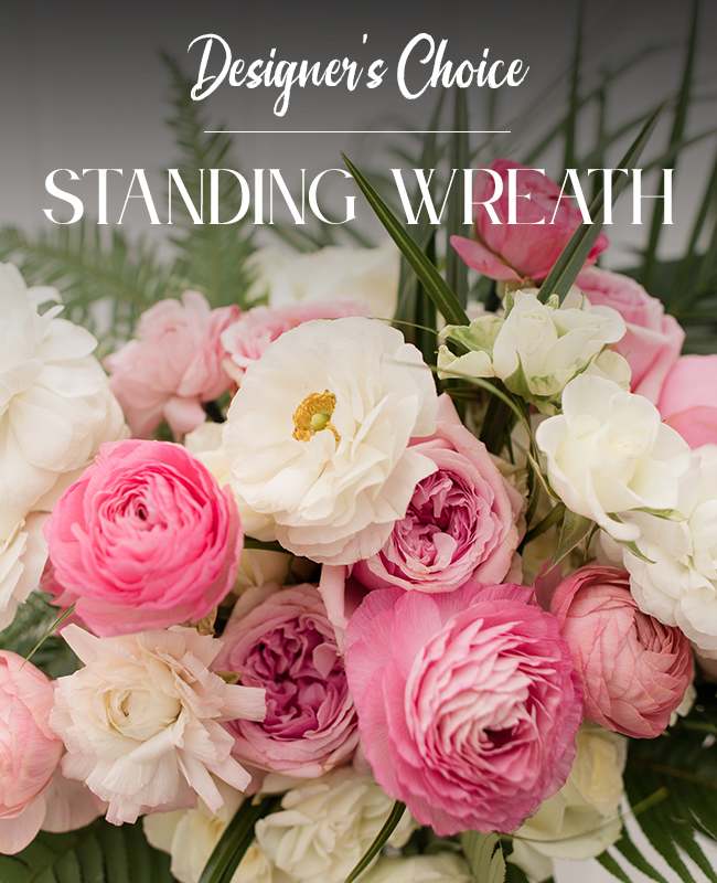 Pink and white standing wreath with layered blooms and palm fronds