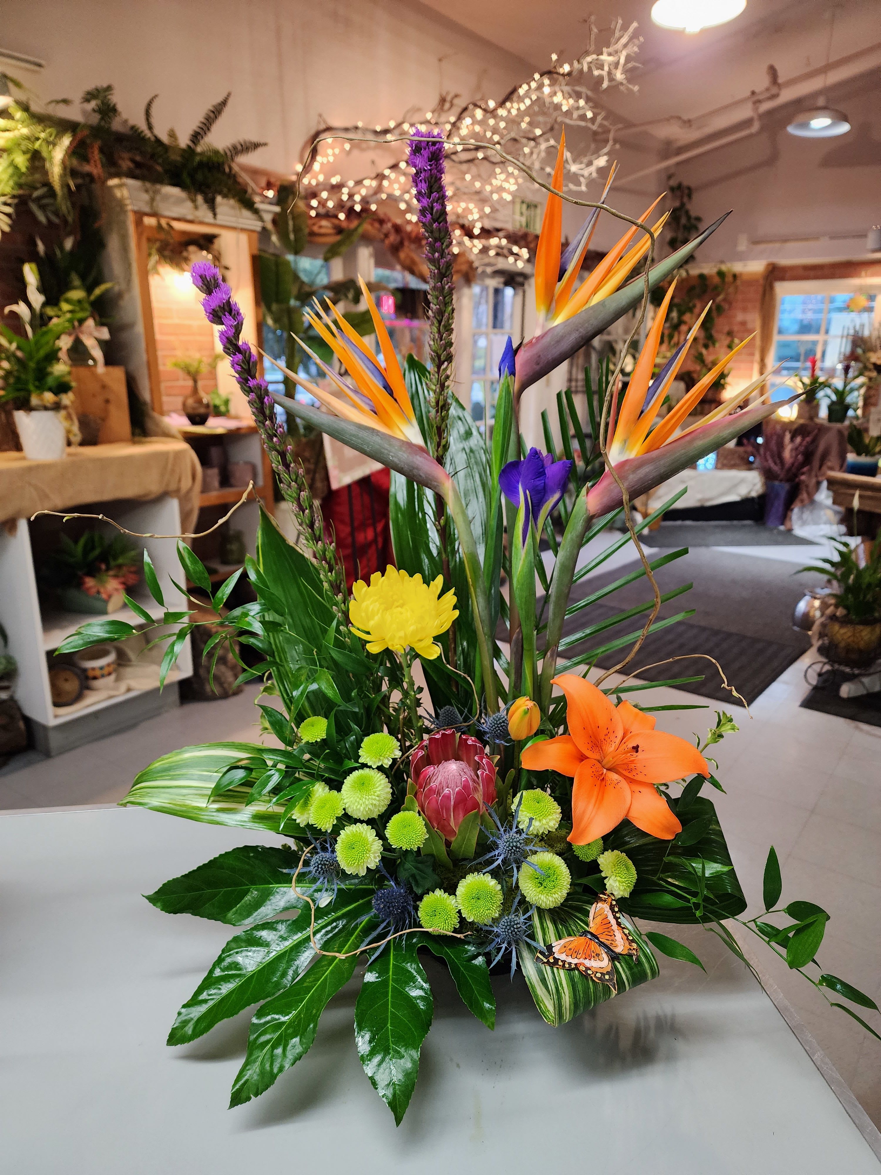 Tropical floral arrangement with orange bird-of-paradise and purple accents