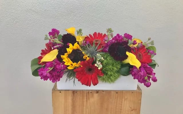 Floral Construction  - Gerberas,  mini calla lilies , sunflowers in white ceramic container 