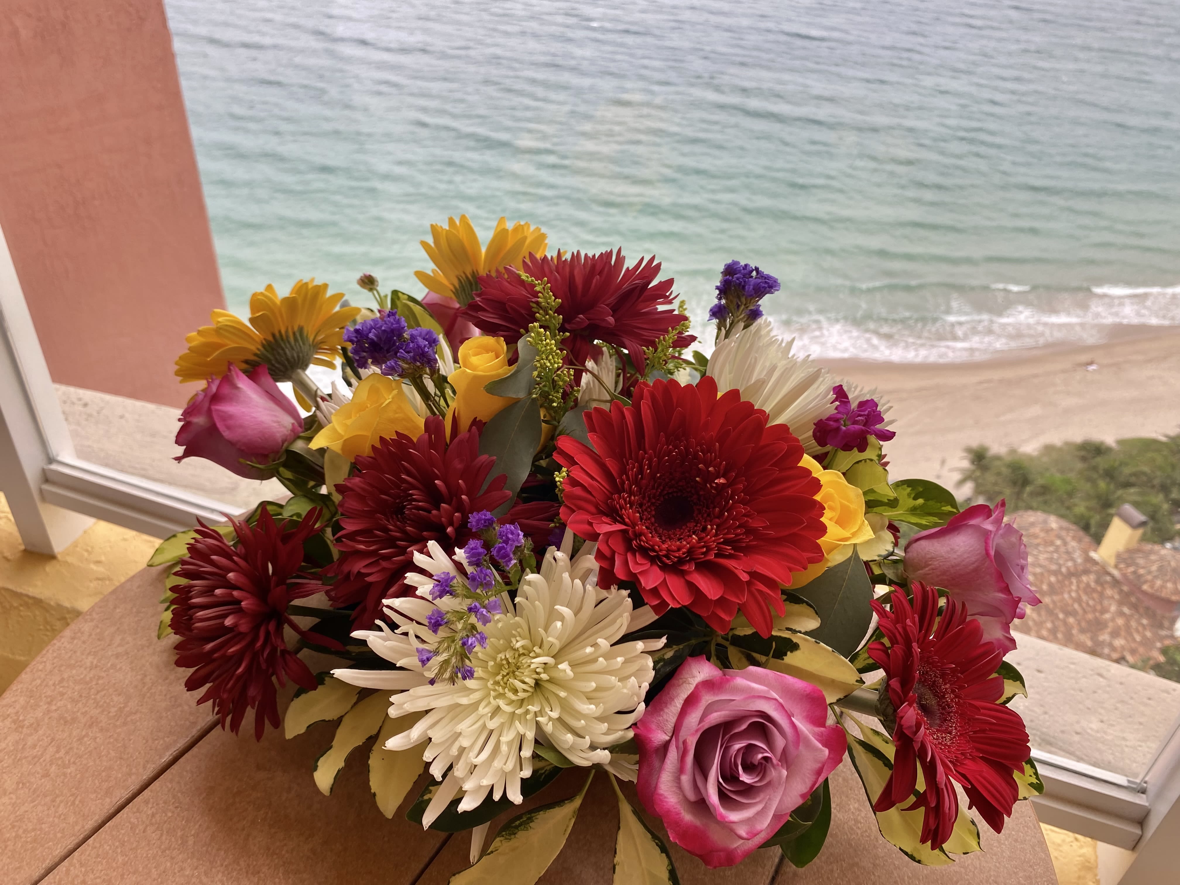 Mixed bouquet of red, pink, yellow, and white flowers on a table