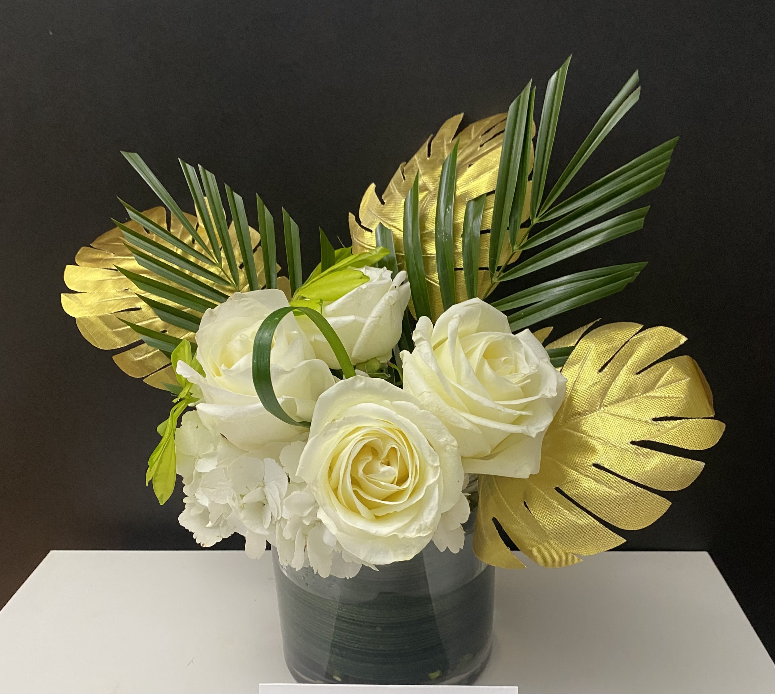 Gold Celebration  - White Roses, Hydrangeas, Palm leaves, Golden Leaves in 6”x 6” glass vase 