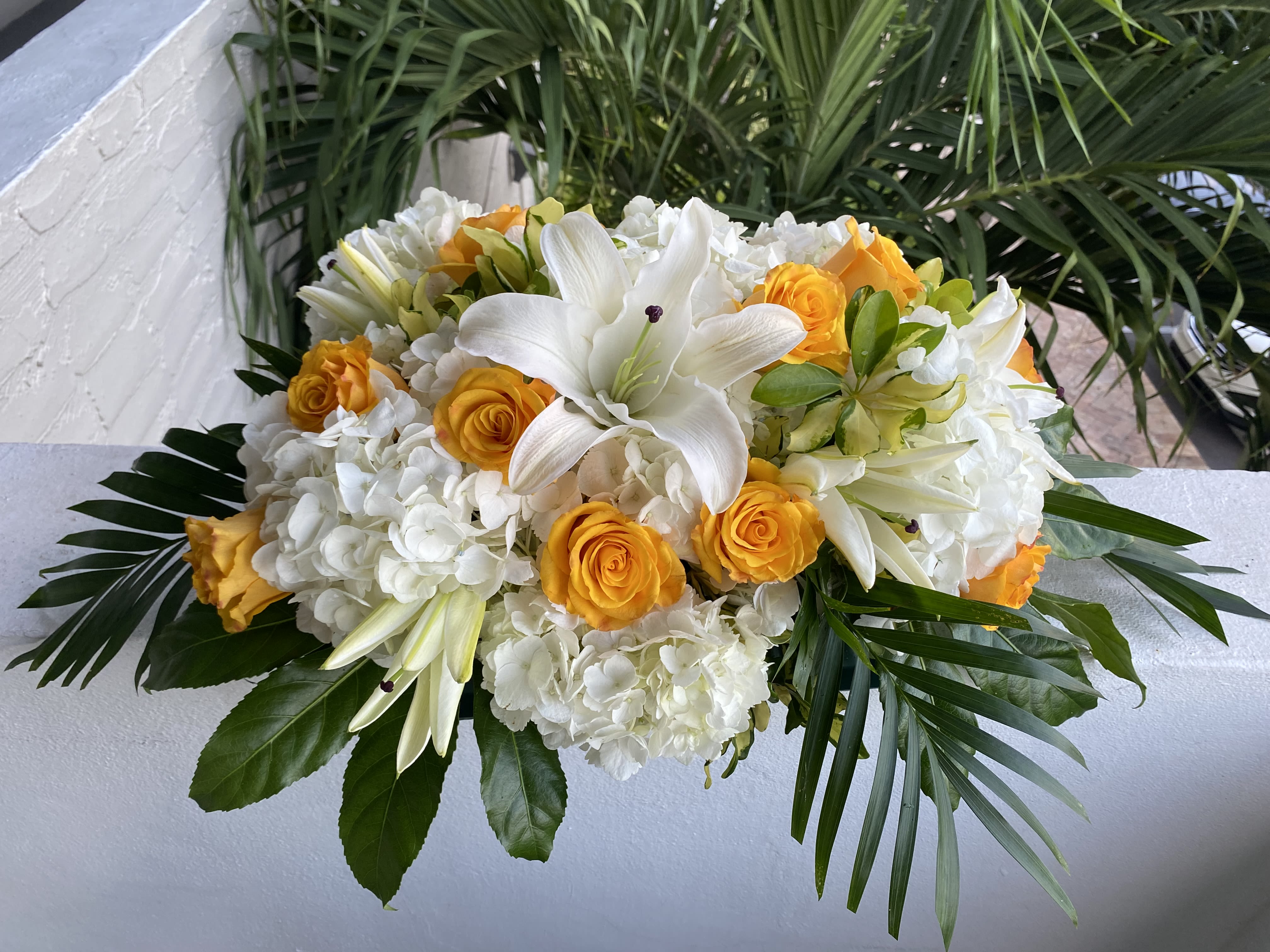 White lilies and yellow roses in a low floral arrangement