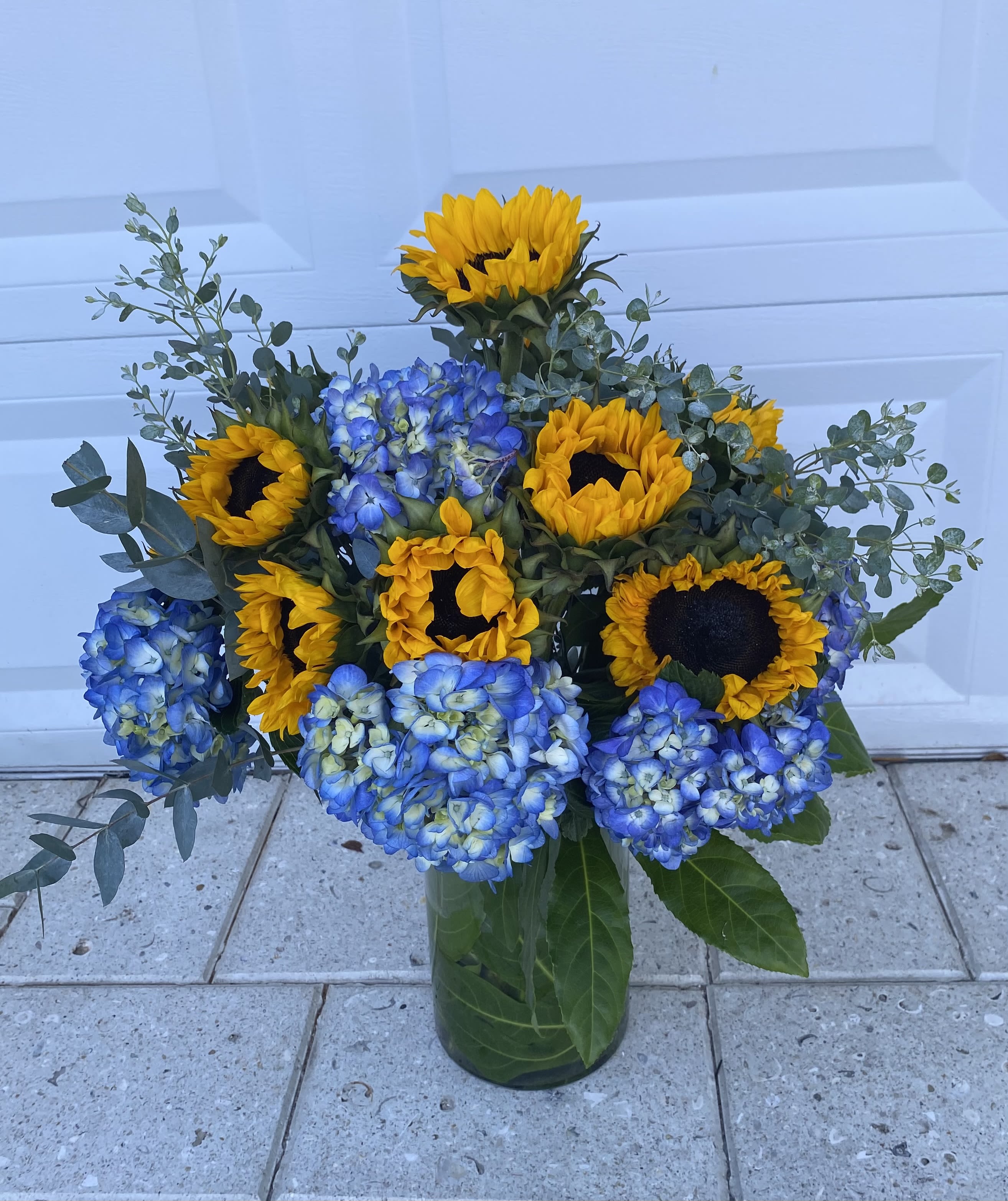 Blue and Yellow  - Sunflowers and blue Hydrangeas in tall glass vase 