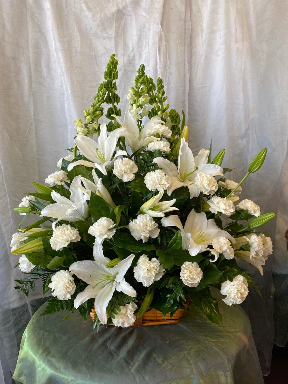 White lilies and carnations arranged in a basket