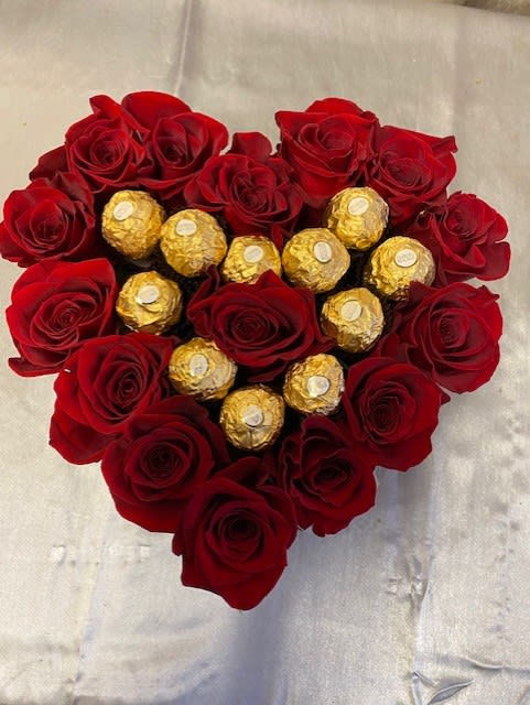 Heart-shaped bouquet of red roses with gold-wrapped chocolates