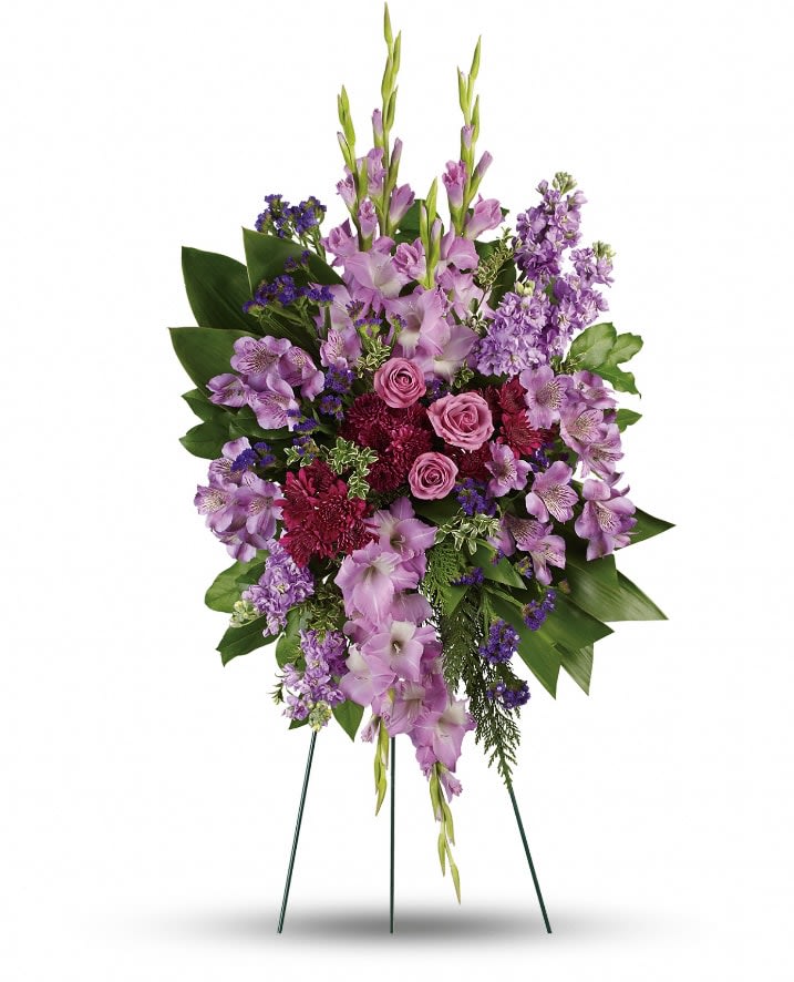 Lavender Reflections Spray - Console and comfort with this luxurious spray of lavender roses, alstroemeria and gladioli. It's a majestic way to remember the departed at the memorial service. This regal spray includes lavender roses, lavender alstroemeria, lavender gladioli, lavender stock, purple cushion spray chrysanthemums, purple sinuata statice, green ti leaves, flat cedar, oregonia and lemon leaf. Approximately 29 1/2" W x 43 1/2" H