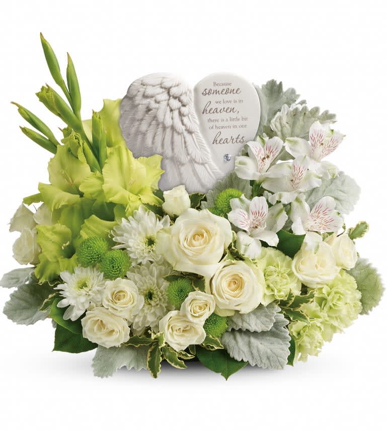 Hearts In Heaven - A heartfelt expression of your sympathy, this majestic mix of white roses will rejuvenate the spirit. Nestled among the blooms is a graceful angel's wing keepsake, etched with an encouraging message they'll cherish forever. Message on sculpt reads: "Because someone we love is in heaven, there is a little bit of heaven in our hearts. White spray roses, white alstroemeria, green gladioli, green carnations, green button spray chrysanthemums, and white cushion spray chrysanthemums are accented with dusty miller, pitta negra, and lemon leaf. Delivered with a Heaven's Heart keepsake. Approximately 16" W x 13" H