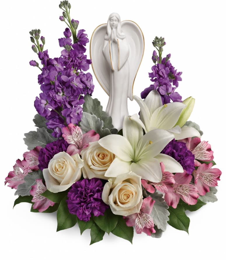 Beautiful Heart - This elegantly sculpted angel is a comforting symbol of love and peace. Part of Teleflora's exclusive Flowers-in-a-Gift collection, this stunning gift is sure to be a great source of comfort and hope for years to come. This beautiful arrangement includes crème roses, white asiatic lilies, lavender alstroemeria, purple carnations, lavender stock, dusty miller and lemon leaf. Delivered with an Angel of Grace keepsake. Approximately 14 1/2" W x 14 1/2" H