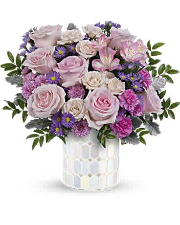 PRETTY POP BOUQUET - ***NOTE: THIS VASE IS CURRENTLY UNAVAILABLE, WE WILL BE USING BLUE OR HOT PINK MOSAIC VASE** THANK YOU FOR YOUR PATIENCE AND UNDERSTANDING  Embrace timeless elegance with our iridescent mosaic glass cylinder, radiating soft pastel shimmer that beautifully complements an overflowing bouquet of pink flowers, adding a touch of artistic charm to any space. Radiate elegance with our iridescent mosaic glass cylinder, capturing soft pastel shimmer and complementing a lush bouquet of light pink roses, alstroemeria, miniature carnations, green carnations, cushion spray chrysanthemums, dusty miller, and huckleberry, making it the perfect Mother's Day centerpiece.   Orientation : All-Around