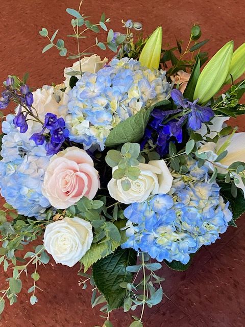 Blue hydrangeas with white and blush roses in a bouquet