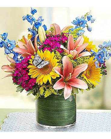 Simple  Sophistication - Celebrate every day with the simple beauty of this best-selling bouquet! Cheerful sunflowers, elegant lilies and more are hand-crafted by our skilled florists in a sleek glass cylinder vase. Accented with a charming butterfly pick, it’s the best way to make someone special in your life smile