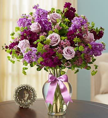 Shades of Purple - Product ID: 105017   It's the gift purple lovers have been waiting forâa gorgeous arrangement of purple and lavender roses, stock and waxflower, accented with fresh greens. Hand-designed by our florists in a classic glass vase, itâs the perfect way to bring out anyone's passion for purple. Lush arrangement of long-stem lavender roses, purple and lavender stock, purple waxflower and bupleurum Artistically hand-designed in a clear glass vase with a stylish decorative ribbon; measures 11"H Large arrangement measures approximately 17"H x 11.5"L Medium arrangement measures approximately 16.5"H x 11"L Small arrangement measures approximately 16"H x 10.5"L Our florists hand-design each arrangement, so colors, varieties, and container may vary due to local availability