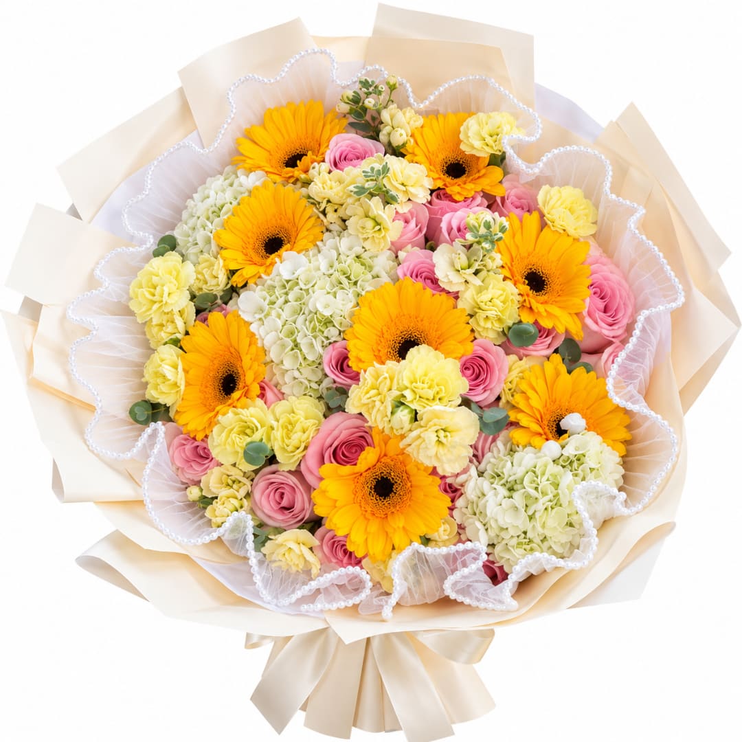 Bouquet of yellow gerbera daisies, pink roses, and pale carnations wrapped in cream paper