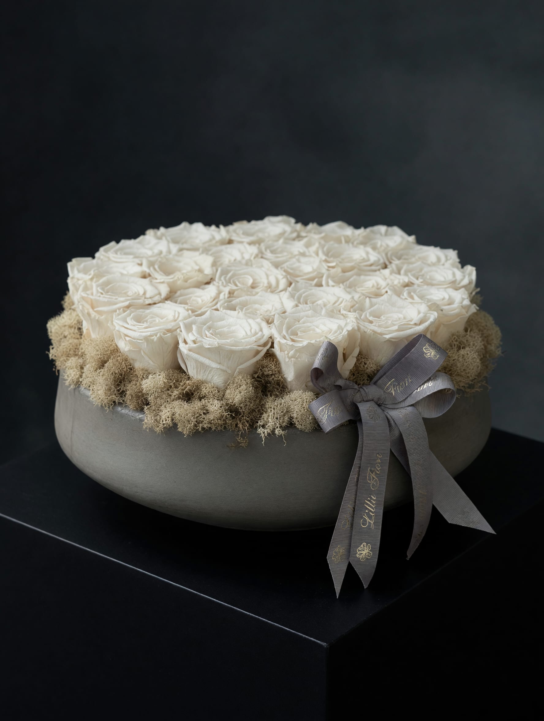 Preserved Roses - Grey Vase - The preserved roses keep their soft, romantic texture without water, so the person you're thinking of will receive a lasting, elegant reminder of care that reads both timeless and restrained. For someone who prefers understated elegance, this is the kind of arrangement that makes them feel quietly seen and comforted. No watering or special care required-keep away from direct sunlight and humidity to preserve the blooms.