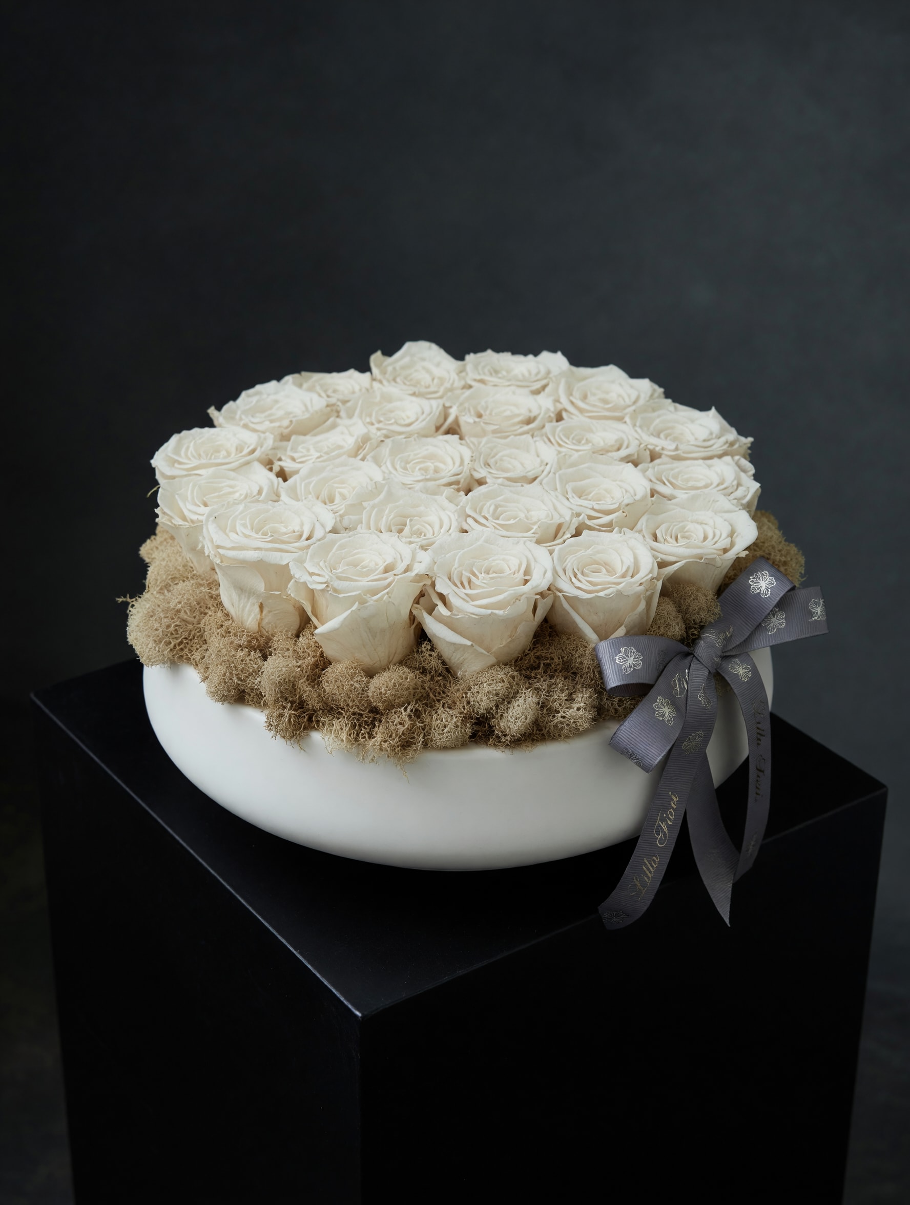 Preserved Roses - White Vase - The soft, long-lasting blooms give the recipient a timeless keepsake that feels both romantic and refined, the kind of gift that makes someone feel truly honored and remembered.  Ideal for someone who appreciates understated luxury, this arrangement arrives ready to display with no water required thanks to the preserved flowers-an enduring way to mark anniversaries, weddings, or moments of remembrance. Choose this piece when you want a gift that looks thoughtfully composed and will continue to bring quiet beauty for months.