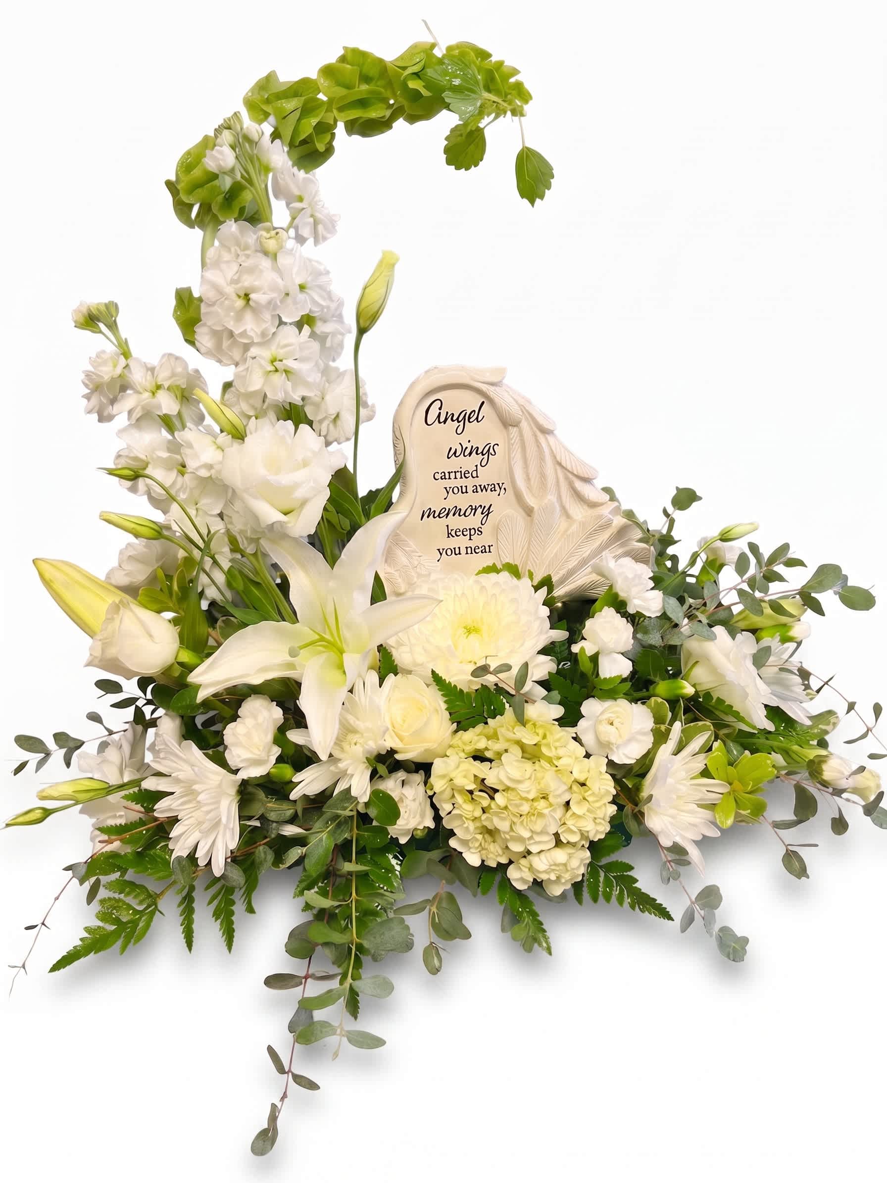 White sympathy floral arrangement with a memorial plaque and angel wings