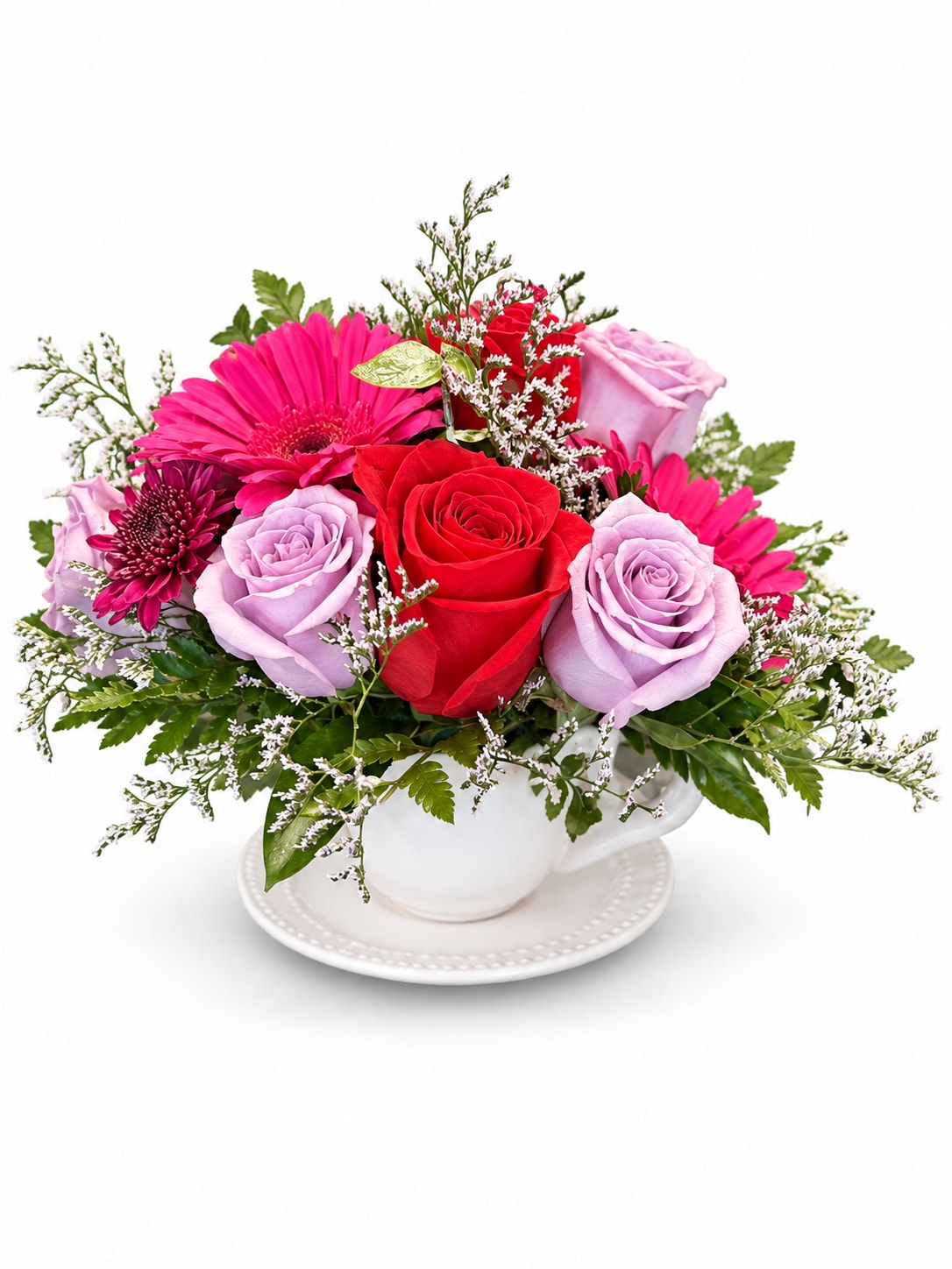 Mixed bouquet of roses and gerbera daisies in a white teacup vase
