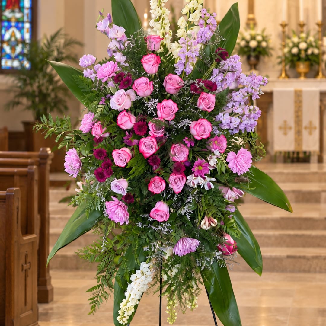 Large pink and lavender floral spray on a stand in a church