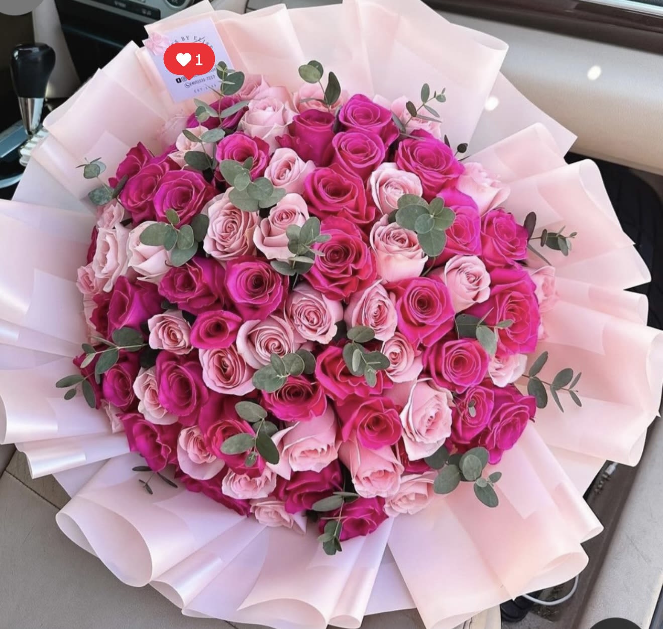 Bouquet of pink and hot pink roses wrapped in pale pink paper