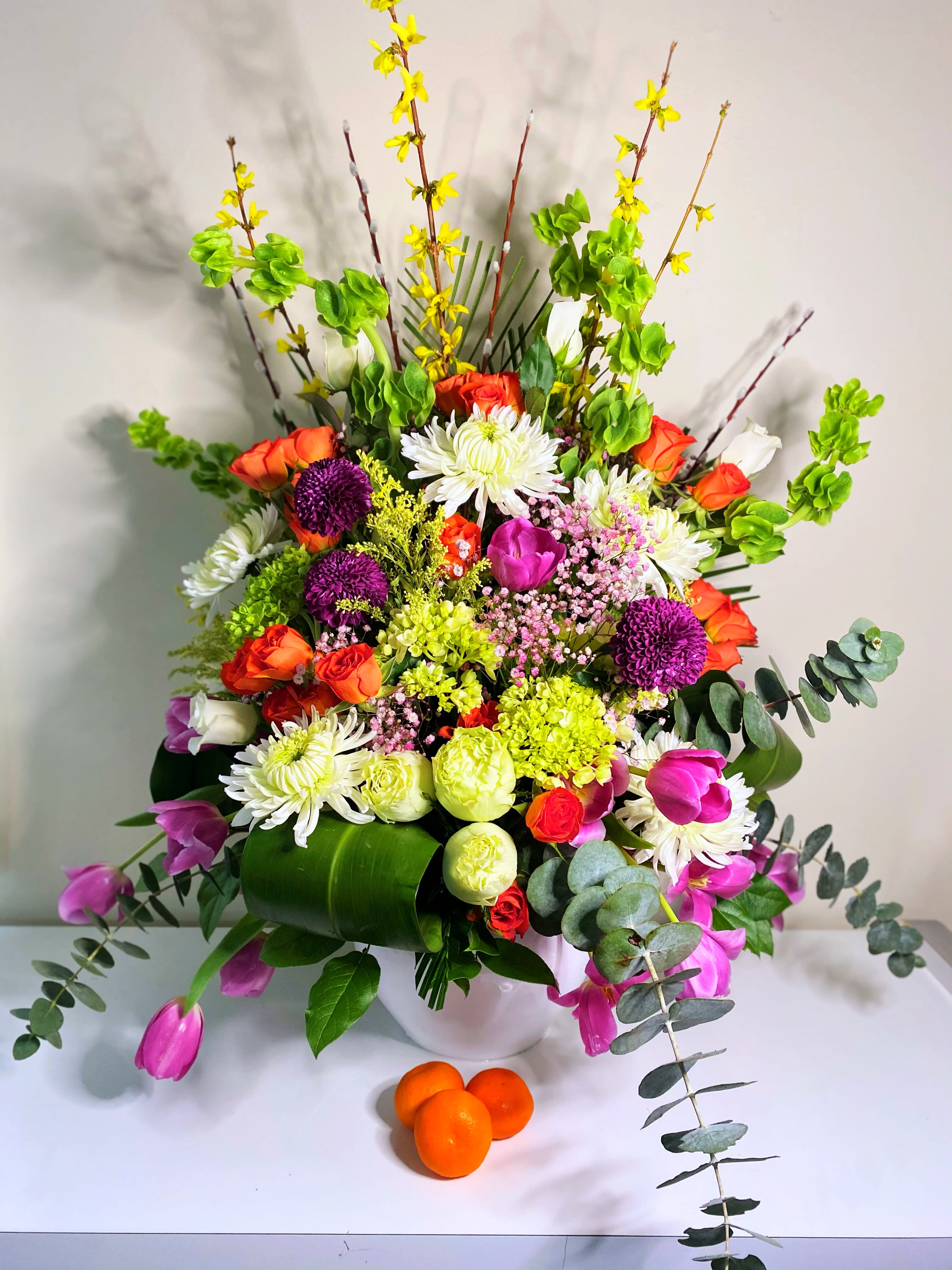 Our condolences  - Our condolences is a floor piece that can also be placed on a short pedestal at the funeral service. Standing about 3. 1/2 ft by 3 ft. Comes in a large white container and is convenient  for the family to take home and fits in a standard suv. The color palette consists of white, green, orange, lavender and yellow. This funeral piece can be made for a male service as well. Just add notes to your order and we can change out the pinks to more yellow or add blues. Indy Joy Blooms can do this in any colors at your request. 