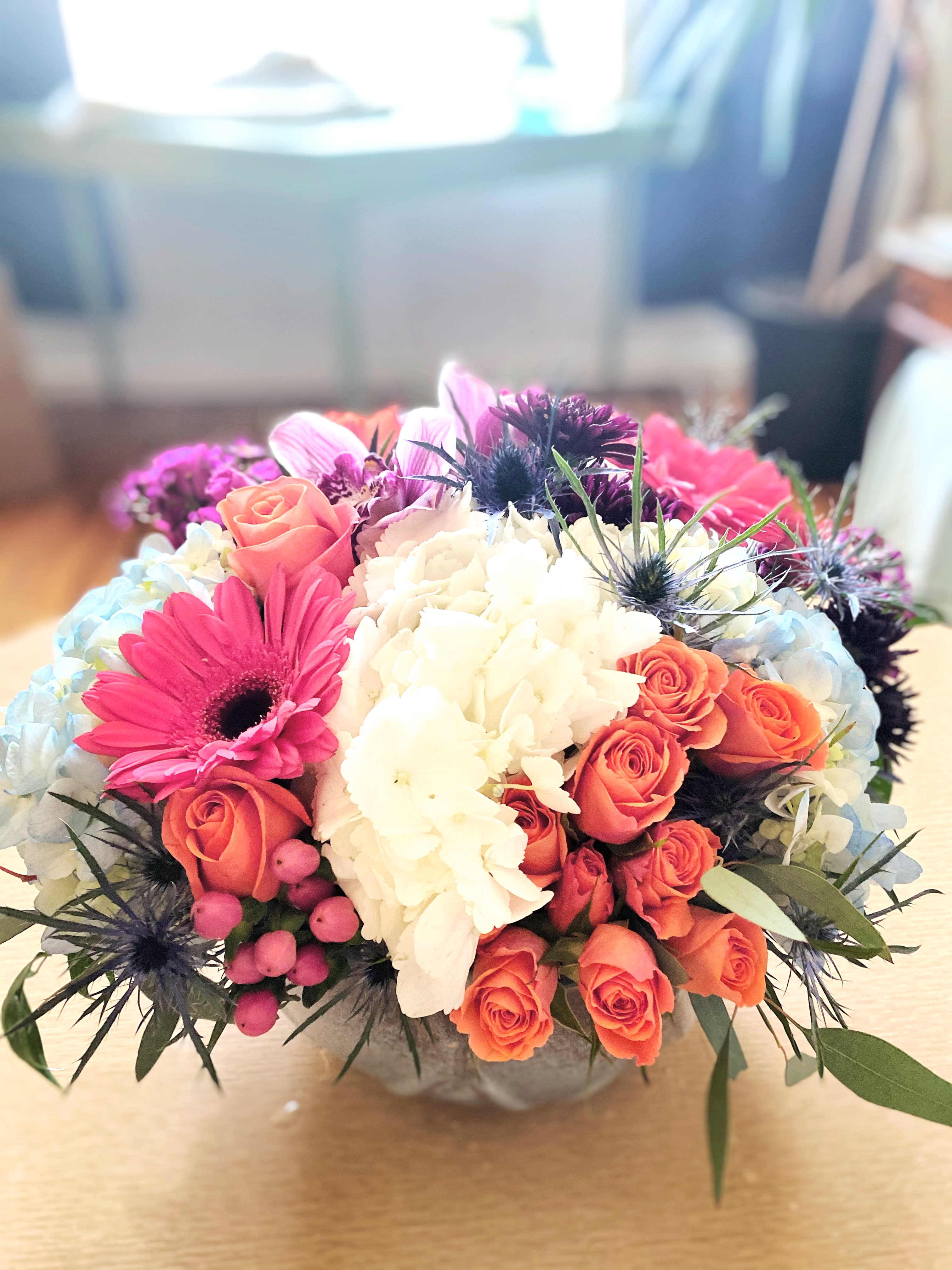 Indy Joy Blooms blue bowl - The blue bowl is a striking and stunning collection of soft colors, baby blue, white, orange, pink and touches of burgundy. It has the feel of a garden in a pond. Flowers may vary as we use the freshest in the market of the day but we will stay true to the color palette and the value of the flowers arrangement. Perfect to send to wish someone happy anniversary, happy birthday, thank you it just because! The container is a ceramic blue bowl, a keepsake that can be used as a planter or just to put your keys in by the foyer. Your gift will definitely Aw your friend or loved one!