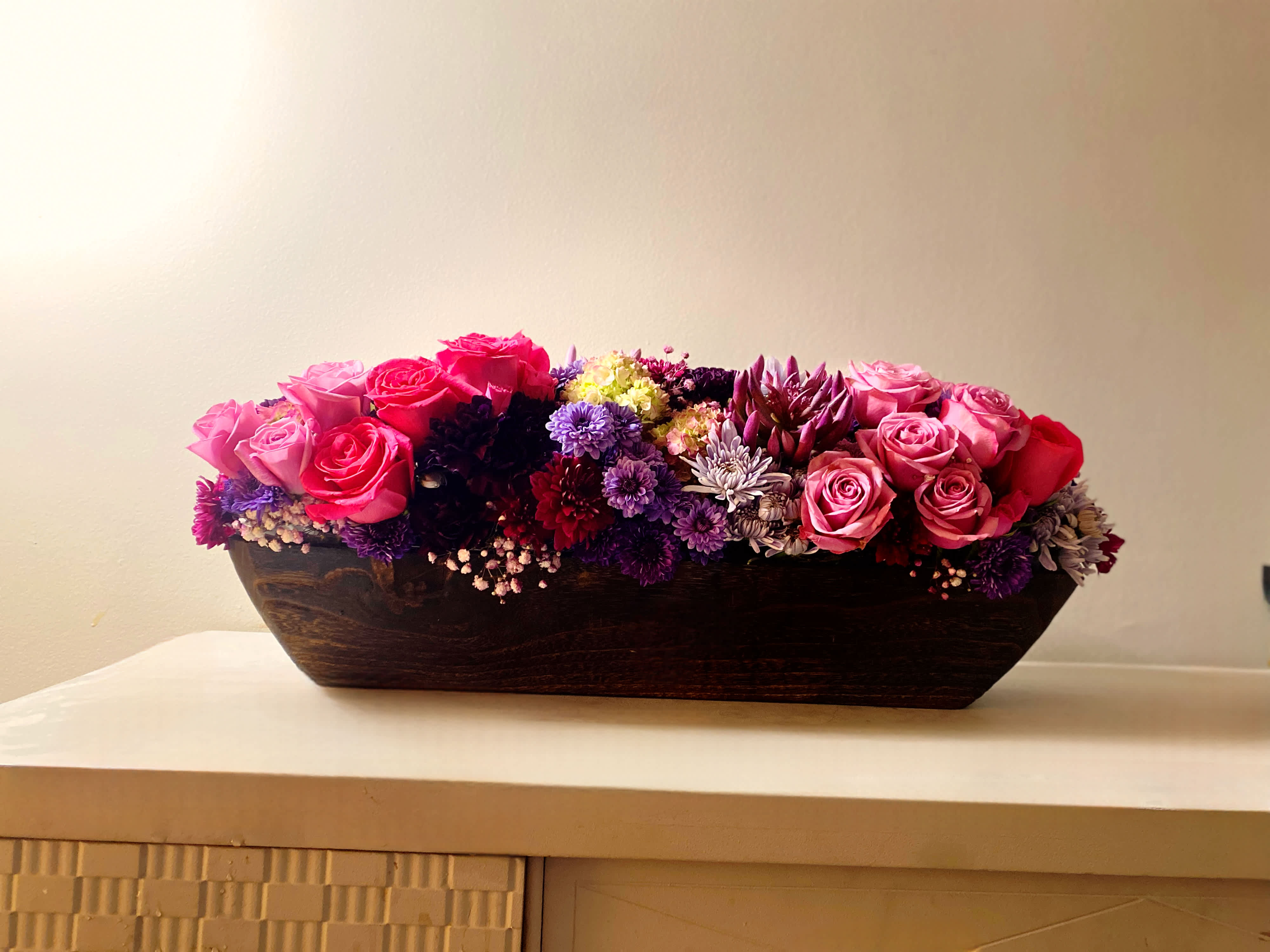 Wood and Blooms - Wood and blooms floral arrangement is a decadent heartfelt design with roses and hydrangea and other premium novelty flowers. This is a long 37 in x 5 in thick wooden boat shaped vessel. This is a high end wooden piece of decor that is a keep sake that can be enjoyed for years to come. Your can nestle moss balls,glass spheres or use it to display fruits in your kitchen island. This design can be ordered in any color scheme. If you want to specify colors you can put it in the special instructions when placing your order. Flowers may vary depending on the best of the market that day.   The Love Boat comes with a large heart Candy and finished off with brown bamboo heart. Send this to your crush or that special someone that pulls your heart strings.Let us help you spread the love with this beautiful design.     