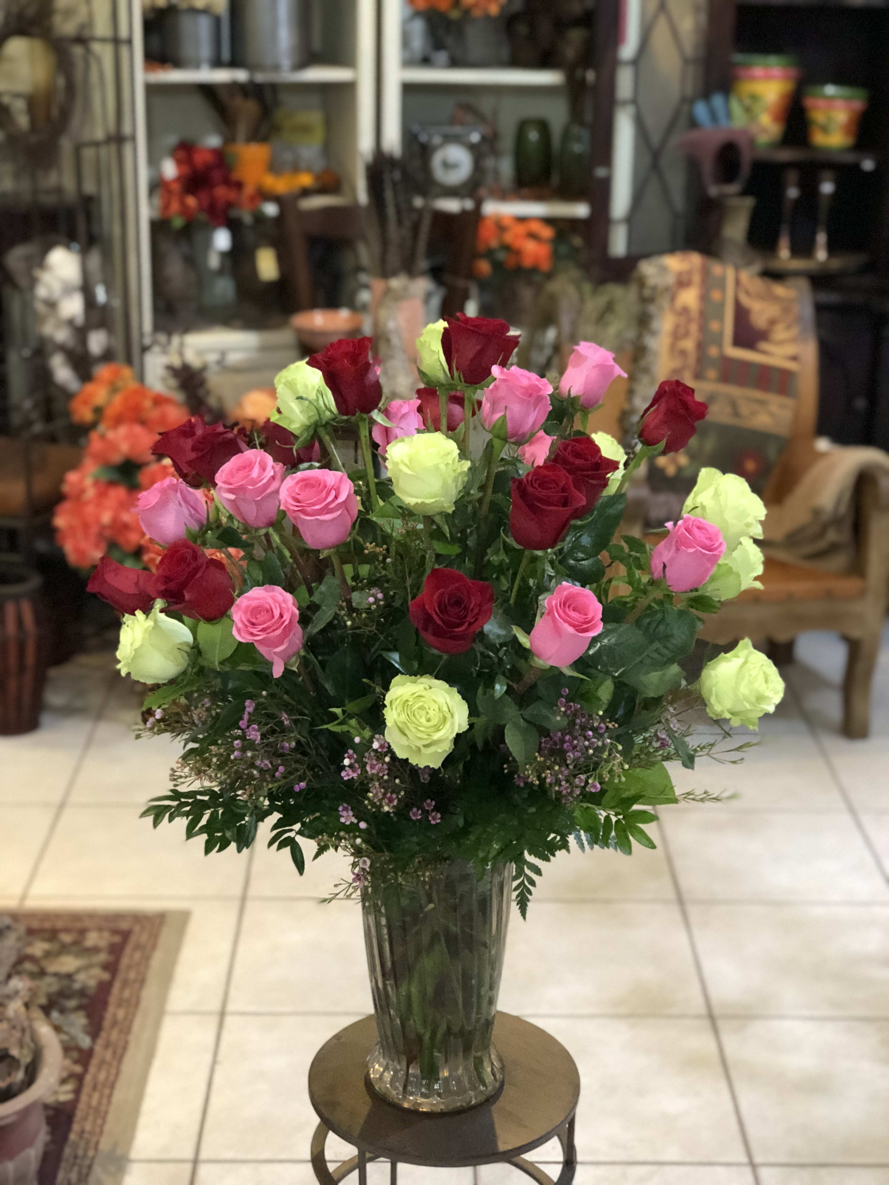 Bouquet of pink, red, and lime roses in a clear glass vase