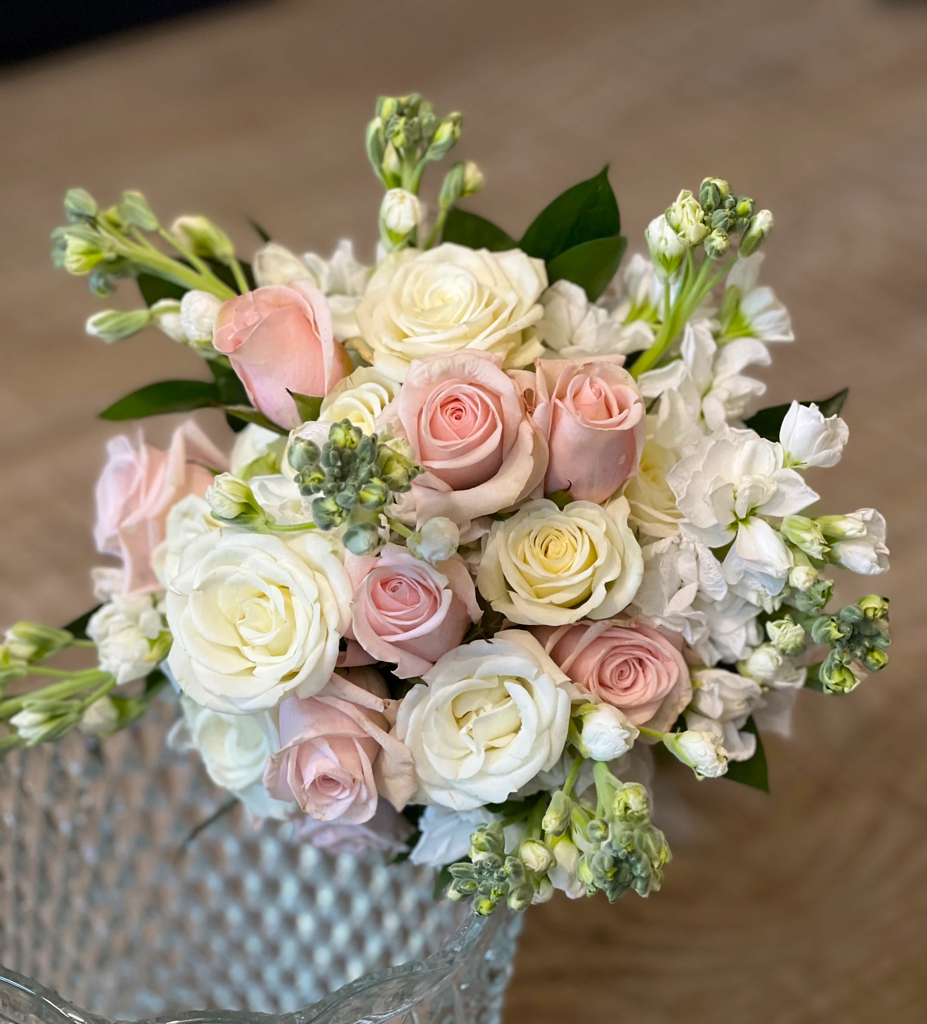 Bouquet of pale pink and white roses with white blossoms in a glass vase