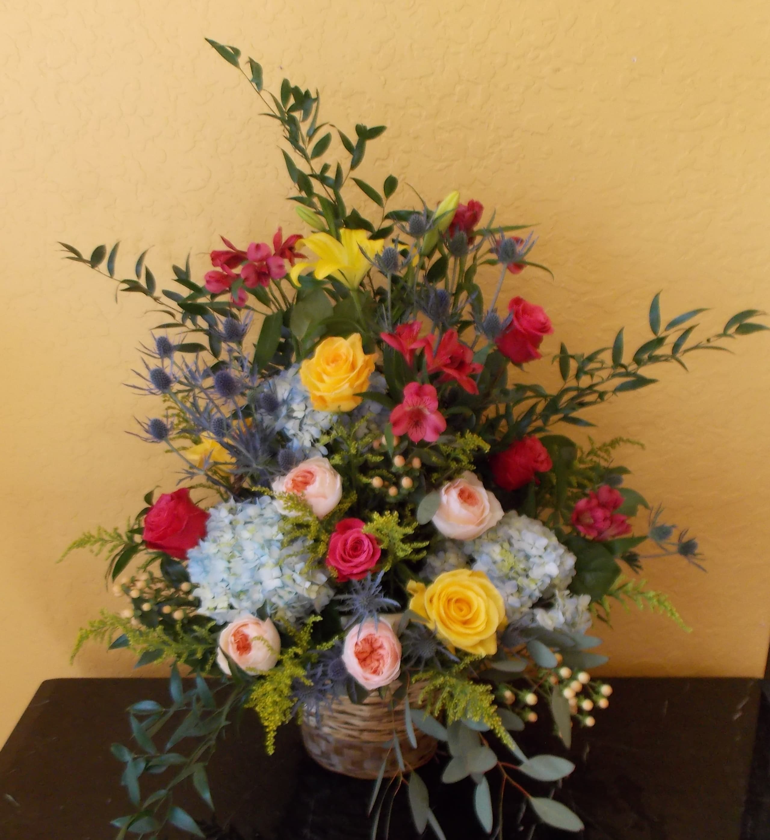Colorful mixed flower arrangement in a woven basket