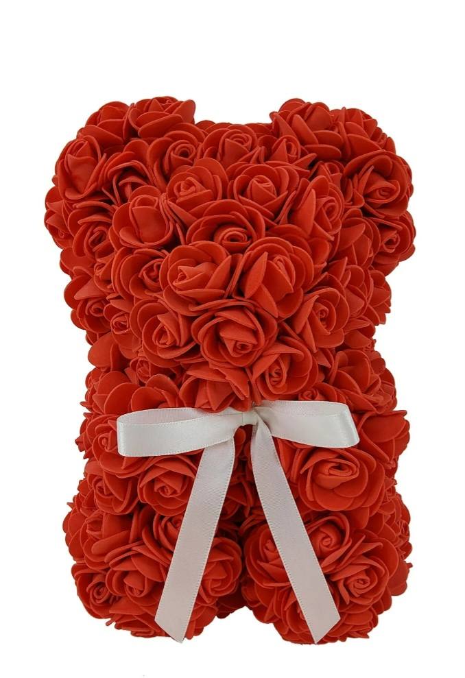 Artificial Rose Bear- Red - A playful, romantic keepsake made from lots of red rose shapes, this artificial rose teddy bear is a charming alternative to a traditional bouquet for Valentine's Day, anniversary gift or other occasion. The teddy bear form reads as decorative and gift-ready, the bright red rose texture making an immediate visual statement that will make the person you're thinking of feel loved and cherished.  Tightly packed red rose blooms cover the entire bear, giving a plush, textured surface that holds shape and won't wilt-paired with a crisp white satin ribbon bow around the middle for a soft contrast. Colors are vivid red with white accent; materials are long-lasting artificial roses mounted on a teddy bear base for a novelty keepsake rather than cut flowers.  Perfect for romantic surprises, desk or shelf display, or as a playful anniversary token, this piece is meant to be enjoyed long after the occasion. No watering or special care required; simply dust gently and keep out of direct sunlight to preserve color.