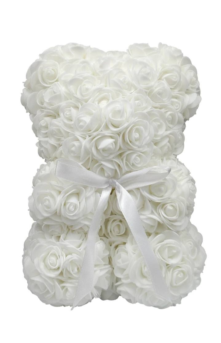 Artificial Rose Bear- White - A plush teddy bear shaped entirely from tightly packed white rose blooms creates an unforgettable, long-lasting keepsake for weddings, sympathy, or quiet anniversary moments. This artificial rose bear-designed as a decorative gift or memorial accent-feels both romantic and refined, the monochrome white palette giving it a calm, elegant presence that reads as thoughtful and comforting to the person you're honoring.  Every inch of the bear is covered in soft-textured white roses, their uniform arrangement forming a smooth, sculpted silhouette that stays pristine without watering or pruning. A white satin ribbon tied around the middle adds a polished, formal touch, making it ready to display on a mantle, bedside table, or at a remembrance service. Because it's made from artificial roses, it requires no care and keeps its shape and color indefinitely-perfect for someone who should be reminded of your sentiment for years to come.