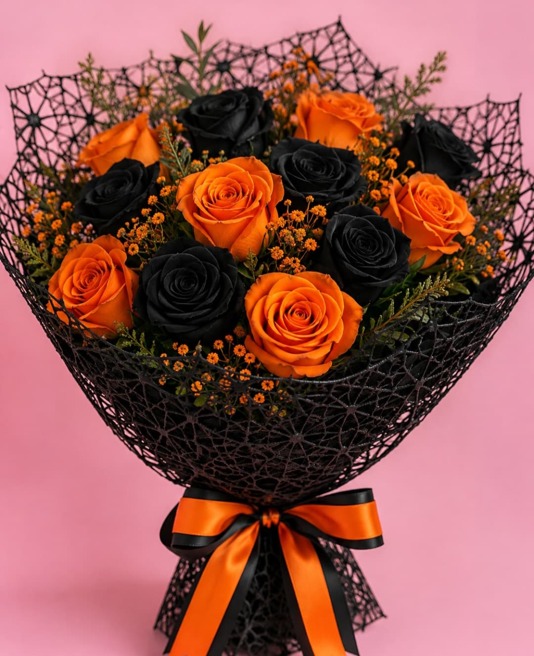 Bouquet of orange and black roses wrapped in black mesh with an orange ribbon