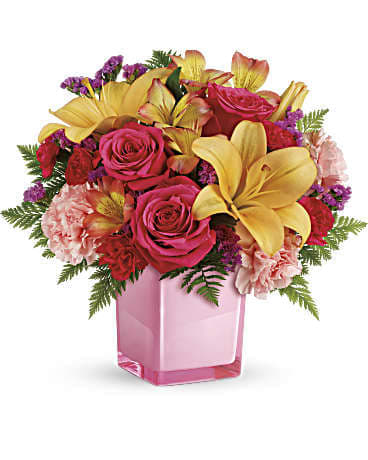 Pink roses and yellow lilies in a pink glass vase