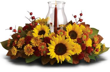 Sunflower and autumn flower arrangement around a glass hurricane candle holder