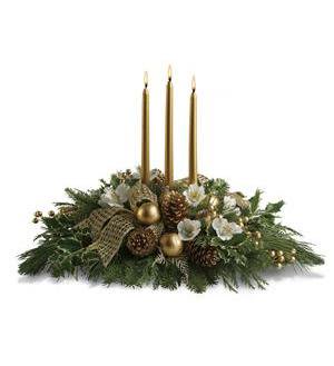 Holiday centerpiece with three gold candles and evergreen decorations