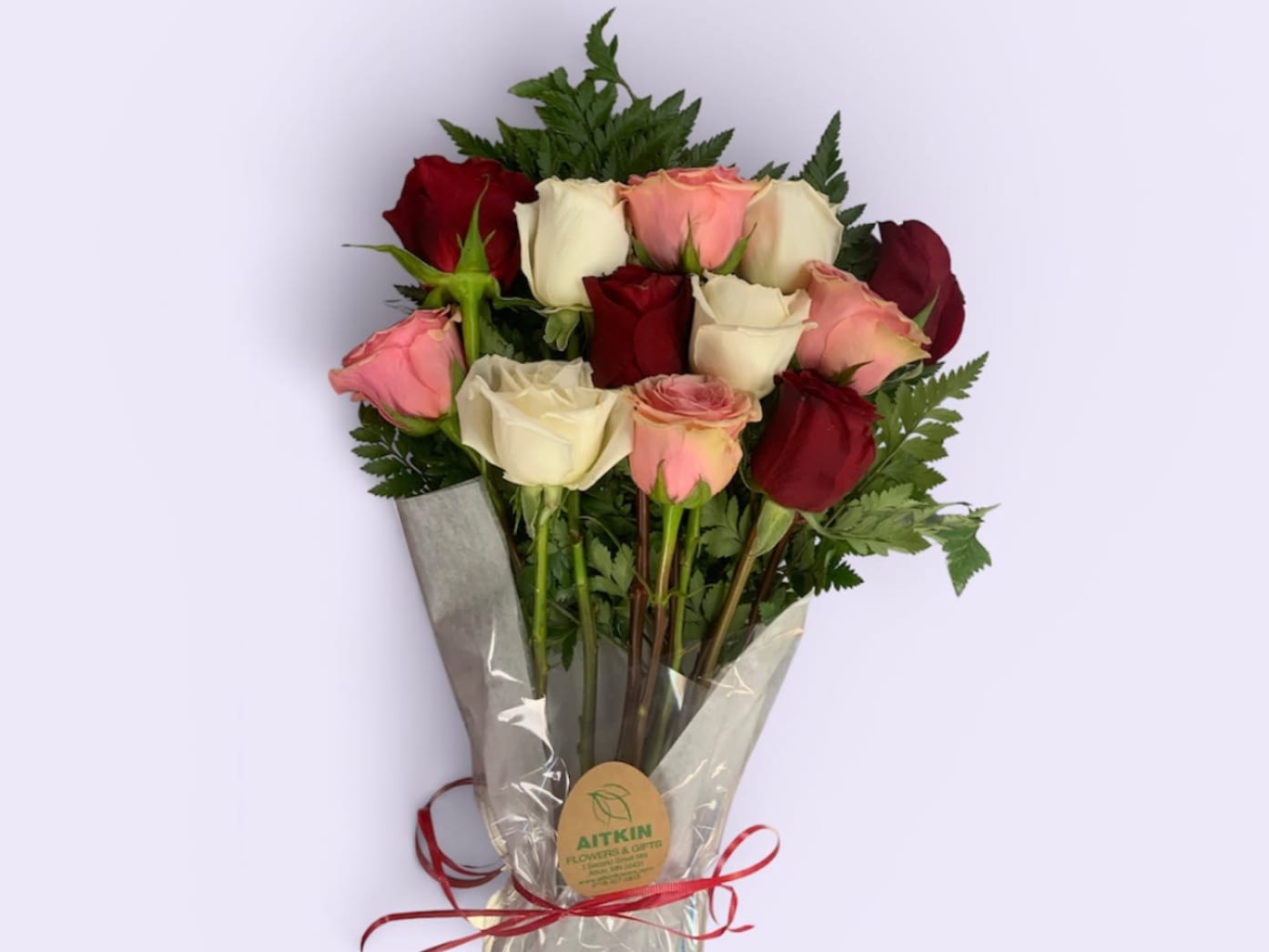 Bouquet of red, pink, and white roses wrapped in clear plastic