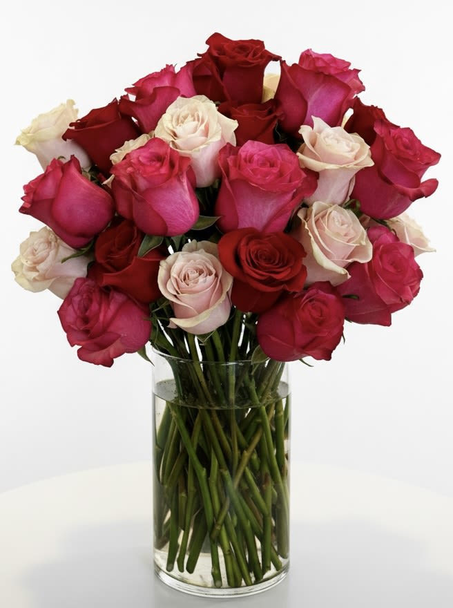 Bouquet of red, pink, and white roses in a clear glass vase