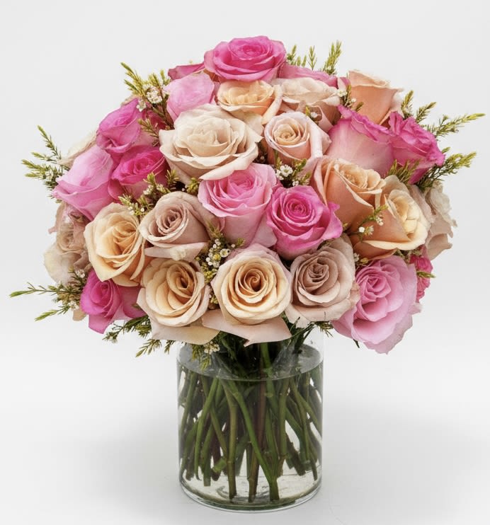 Bouquet of pink and peach roses in a clear glass vase