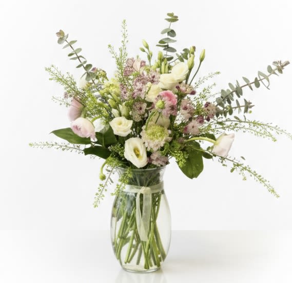 Mixed pastel bouquet in a clear glass vase with a ribbon