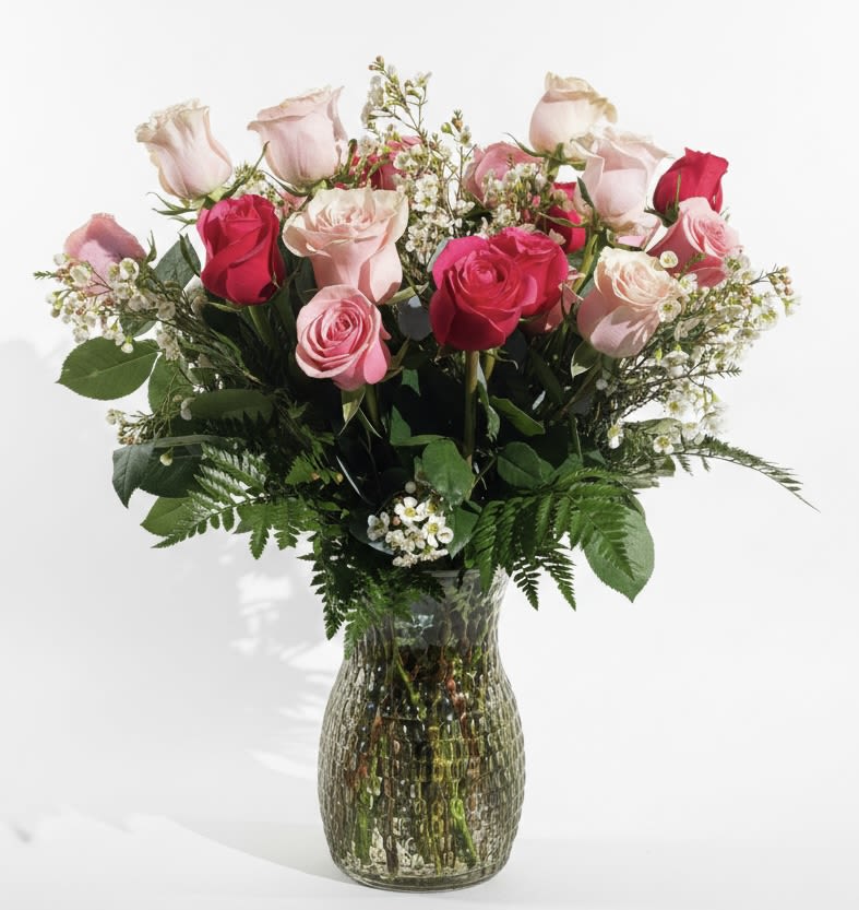 Pink and red roses arranged in a glass vase