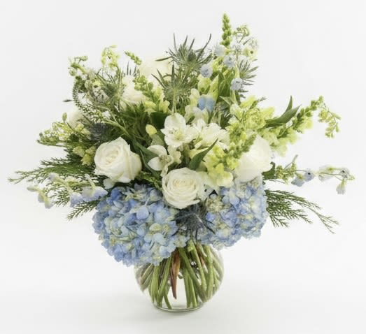 White roses and blue hydrangeas in a glass vase