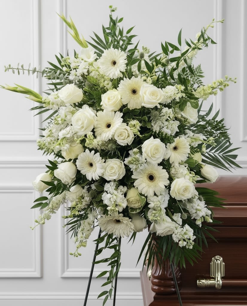 White floral funeral spray with roses and gerbera daisies on a stand