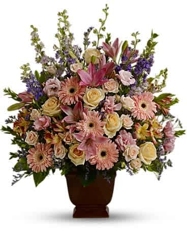 Teleflora's Loving Grace - A warm and peaceful bounty of pastel blossoms gently expresses love and respect. A gracefully composed arrangement appropriate for home or service. Fresh flowers such as peach and light pink roses, lavender and purple larkspur, pink asiatic lilies, alstroemeria, gerberas and lisianthus are set in an exclusive Noble Heritage urn.