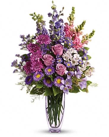Purple and pink mixed flower arrangement in a clear vase